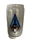A clear can glass with a geometric design featuring the number 3+ in a diamond shape with blue and red elements on the glass.
